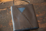 Dark brown pebbled leather back flap with blue leather accent and 'SWAG AND TASSEL' debossing.