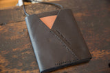 SWAG AND TASSEL embossed on dark leather flap with tan accent and stitching.