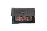Dainty rug fragment wallet in dark textured leather with a colorful woven geometric panel.