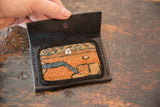 Dainty Rug Fragment Wallet opened, featuring orange, blue geometric rug and black leather stitching.