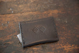 Embossed brand logo on the pebbled, dark brown leather back of the wallet.