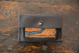 Dainty Rug Fragment Wallet's textured black leather flap with silver snap closure.