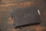 Dark brown pebbled leather wallet showing embossed brand logos and neat hand stitching.