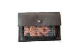 Dainty rug fragment wallet featuring dark brown leather and colorful geometric woven textile.