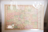 Vintage 1907 Cram's Colorado map showing pastel-colored counties, in protective sleeve.