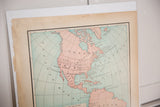 Angled view of Cram's 1907 map, highlighting pink North America and historic paper patina.