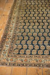 Detailed corner of an antique Tabriz rug, showcasing dark navy boteh with multi-bordered patterns.