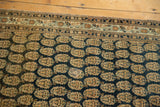 Finely woven antique Tabriz rug, repeating ivory and rust boteh on a dark navy field.