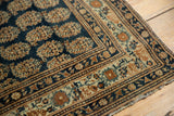 Finely woven antique Tabriz rug corner, navy field and intricate ivory border.