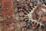 Vintage Karaja rug with dark navy field, geometric brick red florals, and rich texture.