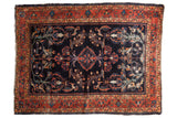 Navy blue field vintage Lilihan rug with central serrated medallion and brick red floral border.