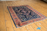Vintage Lilihan rug field, navy blue, oversized floral blossoms, dusty raspberry border.