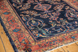 Vintage Lilihan rug showing navy field, gold inner border, and oversized floral blossoms.