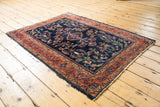 Corner of vintage Persian Lilihan rug, brick red border, floral vinery, light fringe tatter.