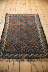 Antique Belouch rug border featuring a reciprocating wave motif, with visible tattered ends.