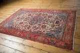 Distressed vintage Meshed rug corner with red border and ivory field, showing even wear.