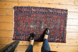 Vintage Lilihan rug corner: cherry red field, blue formal design, and worn fringe.