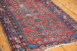 Vintage Lilihan rug's cherry red field with repeating blue and raspberry formal motifs.