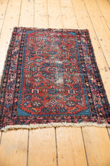 Close-up of worn fringe and traditional cherry red, indigo blue patterns on a Vintage Lilihan rug.