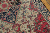 Curvilinear floral vines on antique Farahan Sarouk rug in raspberry, indigo, and ivory.