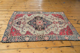 Antique Farahan Sarouk rug corner: raspberry red main border, indigo blue motifs, and ivory field.