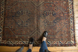 Hand-knotted vintage Shiraz rug displaying robust geometric medallions and time-softened hues.