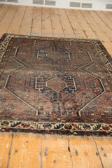 Vintage Shiraz rug's geometric double medallion, madder root red and deep indigo blue palette.