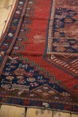 Cherry red field and indigo blue geometric stepped border on antique Caucasian rug.