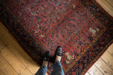 Antique Kashan rug with raspberry red field, displaying leopard, birds, and dense florals.