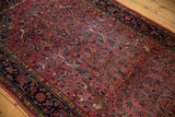 Intricate thousand flower and bird motifs with time-softened tones on an antique Kashan rug.