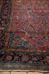Antique Kashan detail: raspberry field, navy border, intricate birds, thousand flower motifs.