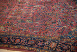 Antique Kashan rug's raspberry red field, filled with birds, florals, and a navy blue border.