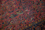 Antique Kashan rug detail: dark raspberry field, intricate birds, thousand flowers, and aged wear.