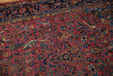 Antique Kashan detail: raspberry field with indigo flowers, birds, and even pile wear.