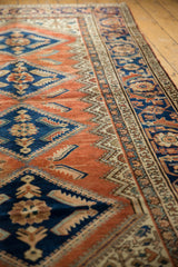 Terracotta and navy field of a vintage Hamadan runner, serrated fish elements and Herati motifs.