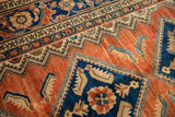 Vintage Hamadan rug, terracotta field, navy floral medallion, sky blue serrated motifs.