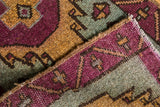 Vintage distressed Oushak rug's secured side, showing even pile wear and playful village weave.