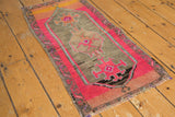 Vintage Distressed Oushak rug corner, showing bright fuchsia and charcoal geometric village weave, with even wear.