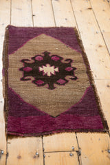Distressed Oushak rug mat featuring a playful, asymmetric village weave in magenta and brown.