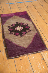 Purple aubergine corner and fringe of a distressed Oushak rug with even wear.