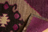 Distressed pile texture, secure woven edge, and bold aubergine pattern of vintage Oushak rug.