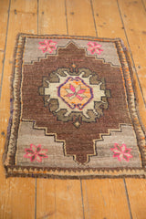 Distressed texture and bright pink star motif on the silver and brown Oushak rug mat.