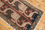 Playful asymmetric patterns in charcoal, beige, terracotta, and blue on a vintage Oushak rug.