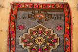 Playful fuchsia, tangerine border with weave inscriptions on a distressed Oushak rug.