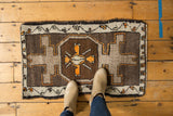Secured side of vintage Oushak rug with tangerine, silver, and charcoal geometric patterns.