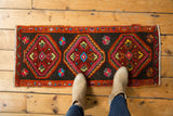 Vintage Oushak rug corner showcasing stepped medallion, floral motifs, and narrow border in cherry red, sky blue.