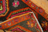 Vintage Oushak rug's hand-knotted pile, secured fringe, and rich tangerine, cherry, saffron palette.