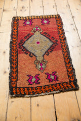 Distressed lower corner of vintage Oushak rug, showing hot pink fuchsia and blood orange geometric patterns.