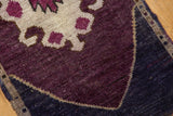 Distressed eggplant, ivory, and navy motifs in a vintage Oushak rug's village weave.