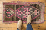 Distressed Oushak rug mat with vibrant hot pink and charcoal geometric patterns.